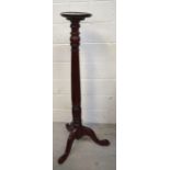 A mahogany torchère with reeded column and carved tripod base, height 132cm.