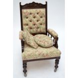 An Edwardian mahogany framed button back armchair, with carved foliate decoration to top rail,