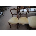A set of four Victorian walnut side chairs with pierced shaped top rails,