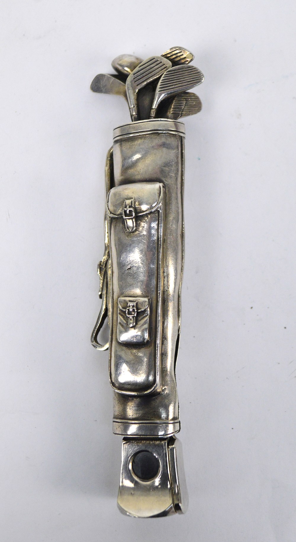 A novelty white metal cigar cutter modelled as a golf bag with clubs, length 14.5cm.