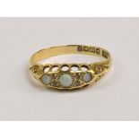 An 18ct yellow gold three stone opal ring, the central opal flanked by melee diamonds, size O 1/2,