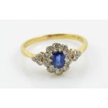 An 18ct yellow gold ring set with oval sapphire surrounded by diamonds,