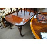 An Edwardian walnut rounded rectangular dining table with single additional leaf and cabriole legs.