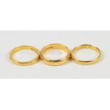 Three 22ct yellow gold wedding bands, one with chamfered edge, all three size K½, approx 10.4g (3).