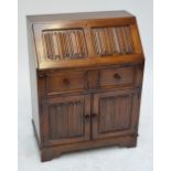 A reproduction oak fall front bureau with linen fold carving,