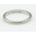 A platinum wedding band with traces of engraved decoration, size O, approx 3.9g.