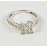 A 9ct white gold and diamond set dress ring, the raised platform set with nine melee diamonds,
