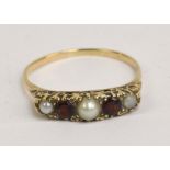 A 9ct yellow gold ring set with three pearls, the central pearl flanked by garnets, size U 1/2,