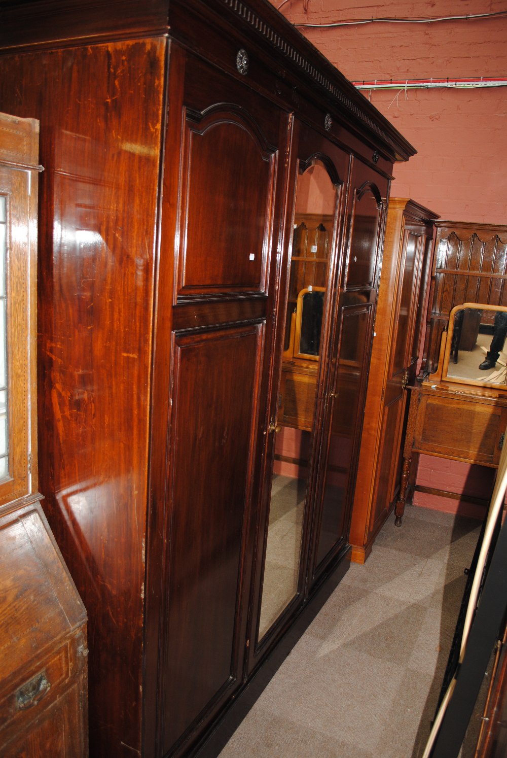 A large Edwardian mahogany three door wardrobe with label inscribed 'Wylie & Lochhead Ltd Glasgow'.