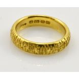 A 22ct textured yellow gold wedding band, size N, approx 8g.