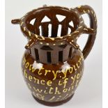 A 19th century treacle glazed slip ware puzzle jug inscribed 'Gentlemen Now Try Your Skill.