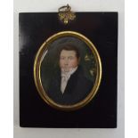 An early 19th century oval portrait miniature of a gentleman wearing white cravat and navy jacket,