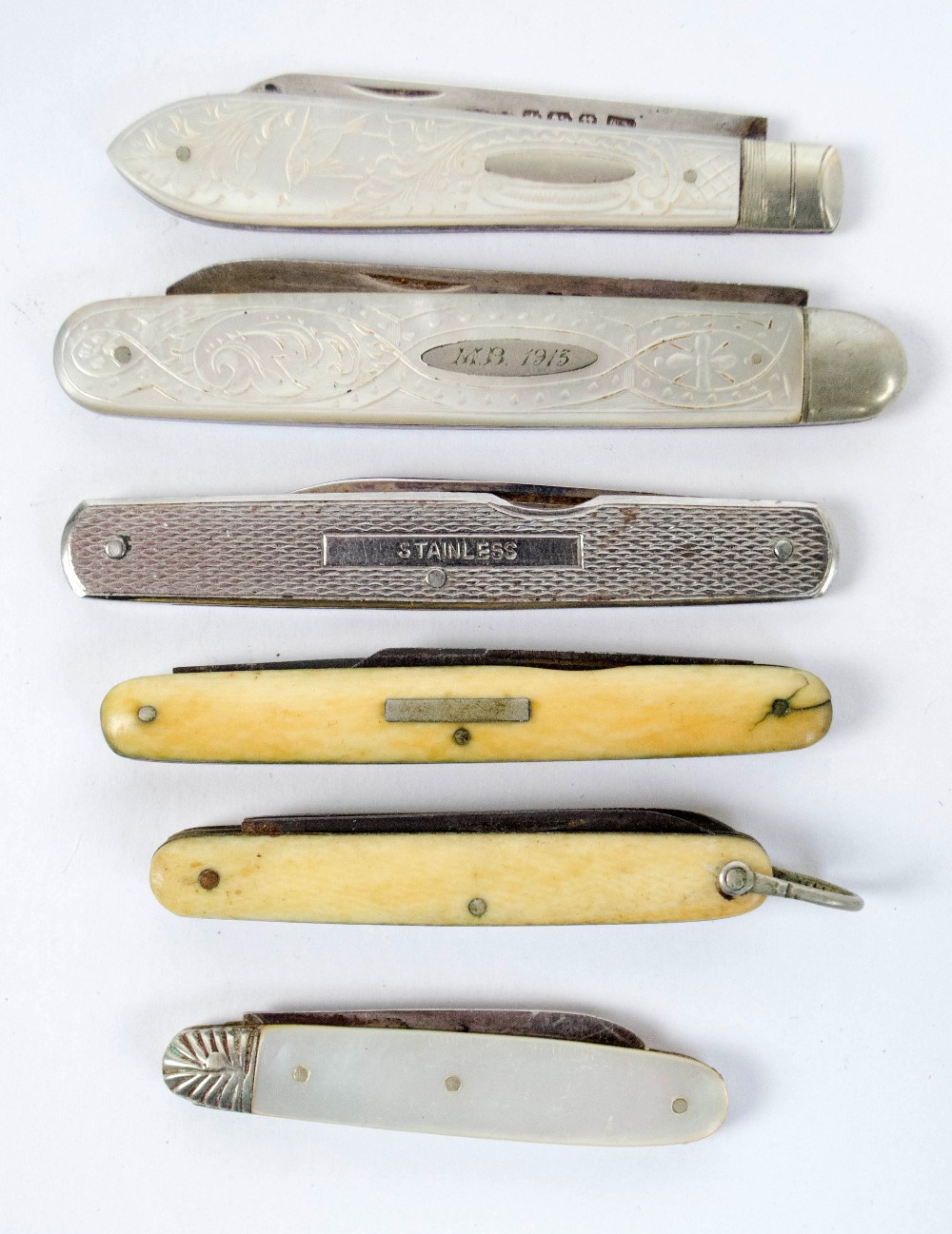 A small collection of pocket knives including three early 20th century examples with mother of