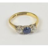 An 18ct yellow gold three stone ring set with central blue spinel flanked by diamonds in claw