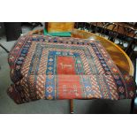 A Turkish hand knotted wool ground rug with central panel decorated with stylised figures and