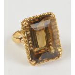 An 18ct yellow gold ring set with large emerald cut citrine in high claw setting and rope twist