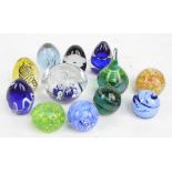 Twelve glass paperweights to include a Caithness black,