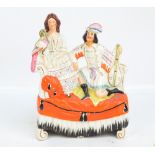 A 19th century hollow Staffordshire figure group modelled as a lady beside an exotic bird by a