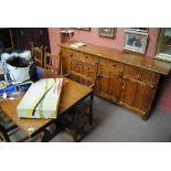 An early 20th century oak dining suite comprising a table,