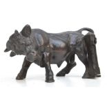 A small late 19th century bronze figure of a bull standing beside a post, unsigned, length 12cm.