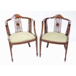 A pair of Edwardian mahogany inlaid open tub chairs with padded seats.