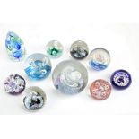 A collection of ten glass paperweights comprising six small Caithness paperweights,