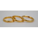 Two 22ct yellow gold wedding bands and a 18ct gold example, all size M (3).