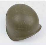 A German WWII BT84 helmet with leather chin strap.