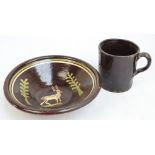 A 19th century naive slip decorated brown glazed bowl decorated with a stag, width 31.