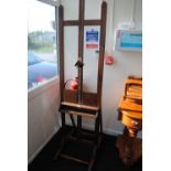 A late Victorian mahogany easel with adjustable brass central rack and square section supports.