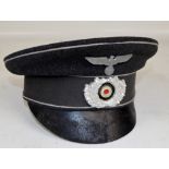 A German peaked cloth cap with spread eagle insignia.