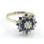 An 18ct white gold sapphire and diamond target ring with central round brilliant cut stone weighing