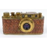 A gilt metal cased snake skin decorated camera inscribed 'Leica, no 258544', in leather case.