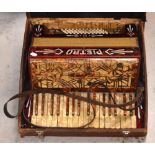 A cased red Pietro piano accordion.