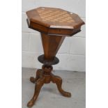A 19th century walnut octagonal sewing table with games board to top,