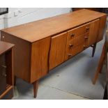 A c1960s 'Beautility' teak sideboard, three central drawers with chrome and wooden knobs,
