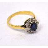 An 18ct yellow gold cluster ring with central faceted oval-cut topaz flanked by baguette and