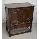 An Ercol priory-style two-door cabinet, one lower drawer to turned supports, length 78cm.