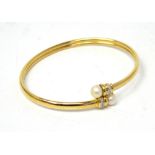 A 14ct gold bangle set with diamonds capped with cultured pearls, approx 6.2g.