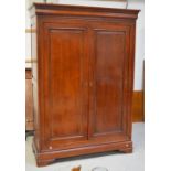 A Simon Horn mahogany twin-door wardrobe with moulded panels to doors and sides,