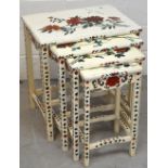 A nest of four ivory-painted tables decorated with swallows and peonies.
