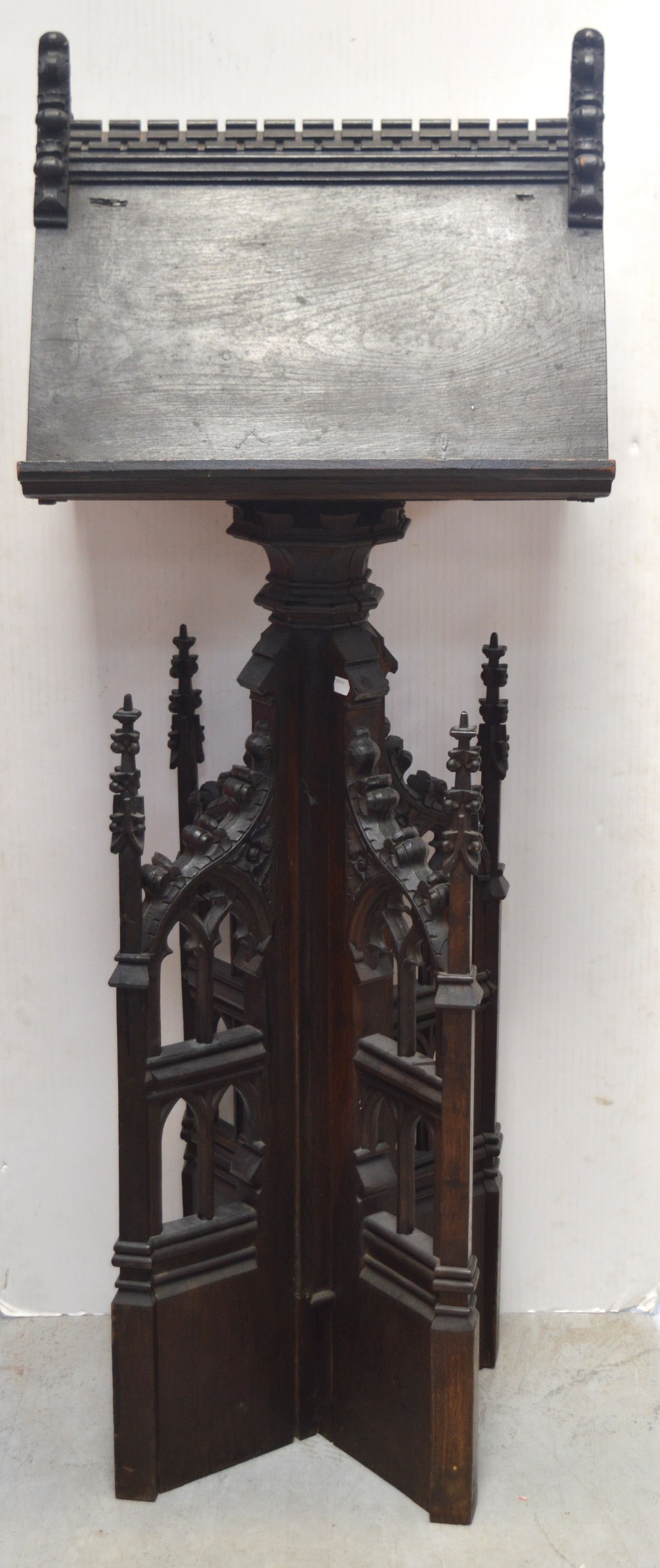 An early 19th century Gothic-style oak ebonised church lectern supported on heavily carved