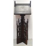 An early 19th century Gothic-style oak ebonised church lectern supported on heavily carved