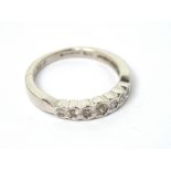 A 9ct white gold seven-diamond ring in rub-over setting, size M 1/2, approx 2.9g.