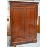 A Simon Horn mahogany twin-door wardrobe with moulded panels to doors and sides,