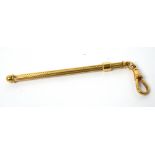 A 9ct yellow gold engine-turned decorated swizzle stick on suspension clip, approx 7.6g.