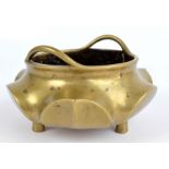 An 18th century Chinese bronze stylised lotus shaped twin handled censer on three cylindrical