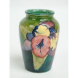 MOORCROFT; An "Orchid" pattern tube lined decorated baluster vase on green ground,