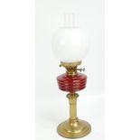 A Victorian brass and glass oil lamp with ruby glass reservoir,