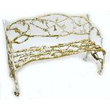 A Victorian painted cast iron garden bench, naturalistically modelled as branches.